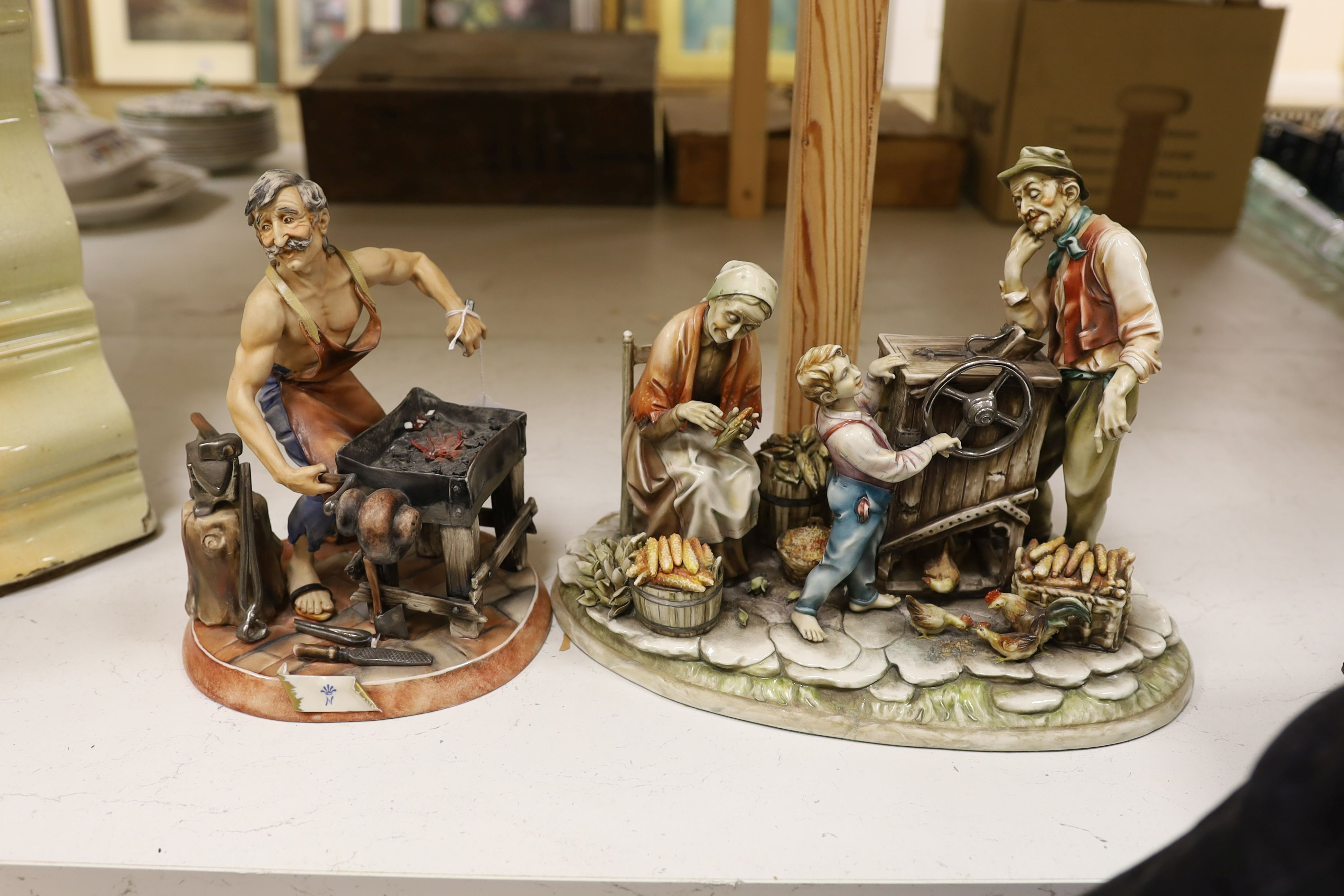 A Capodimonte figure group of a peasant family with organ grinder together with a smaller figure of a blacksmith, Organ grinder figure group 32 cms wide.